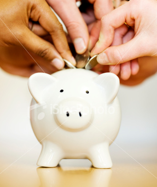 small white piggy bank and hands putting in coins