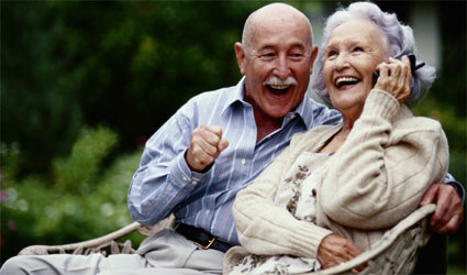 an older couple laughing and smiling while talking on cell phone an older couple laughing and smiling while talking on cell phone