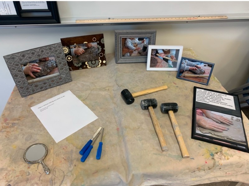 A table in an ECE centre that has framed photos and rubber mallets on top