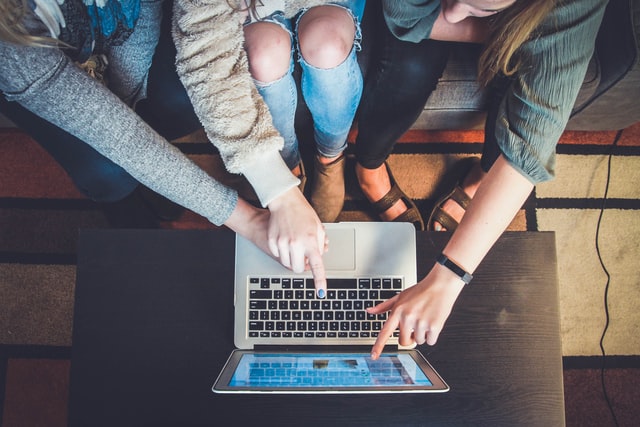 Picture of people pointing at a computer screen